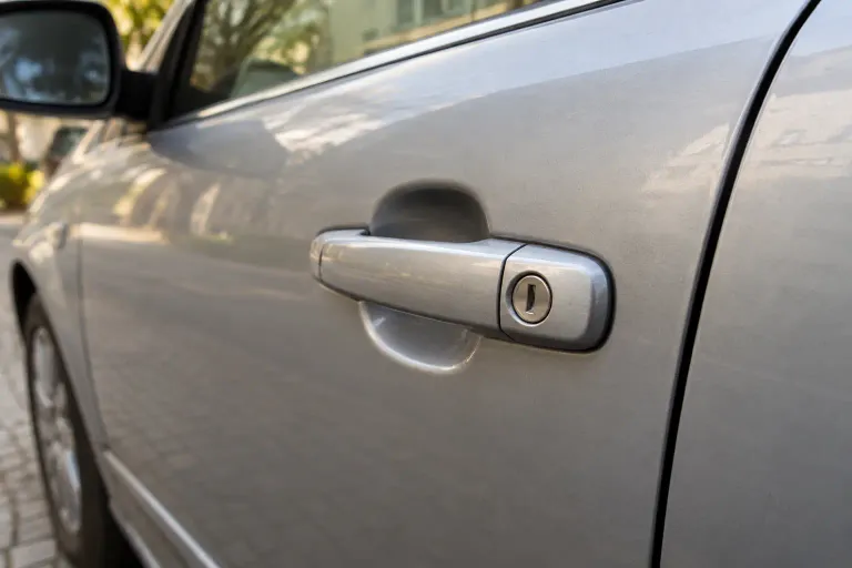 Manija y cerradura de la puerta de un automóvil plateado